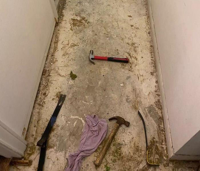 Hallway with hammers on dirty subfloor