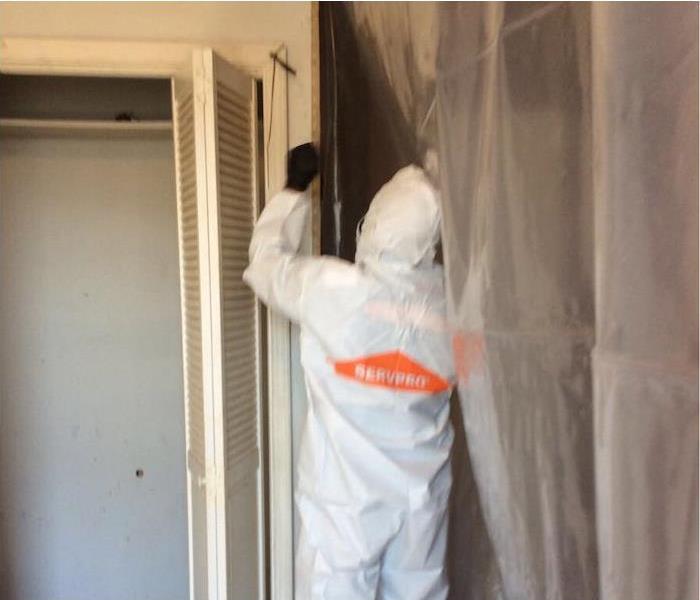 SERVPRO employee setting up a containment barrier in a mold damaged room